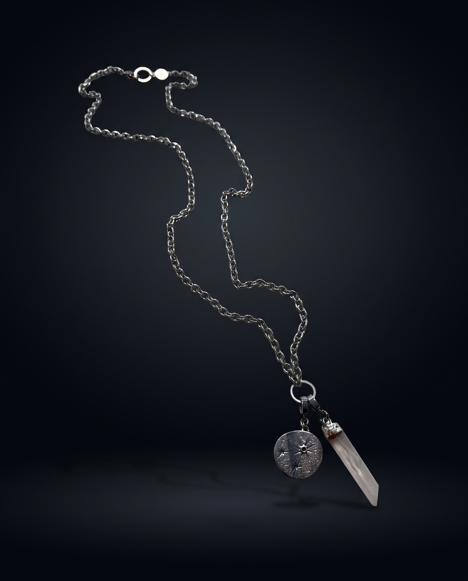 Long Length Hecate silver charm necklace suspended against a dark background, with an 80cm textured chain, clear quartz point and round Star Gazer Disc.