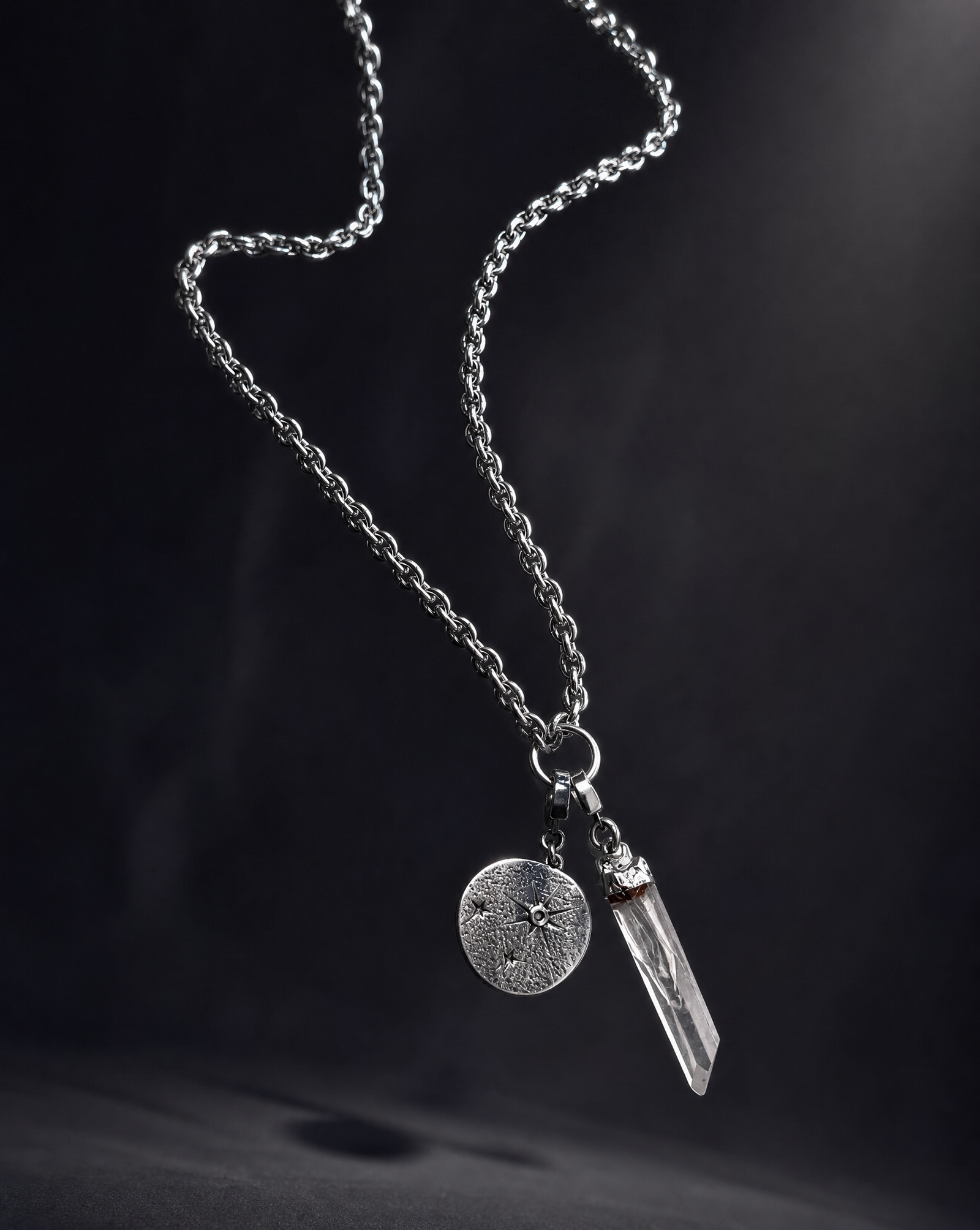 Long Length Hecate silver charm necklace suspended against a dark background, with an 80cm textured chain, clear quartz point and round Star Gazer Disc.