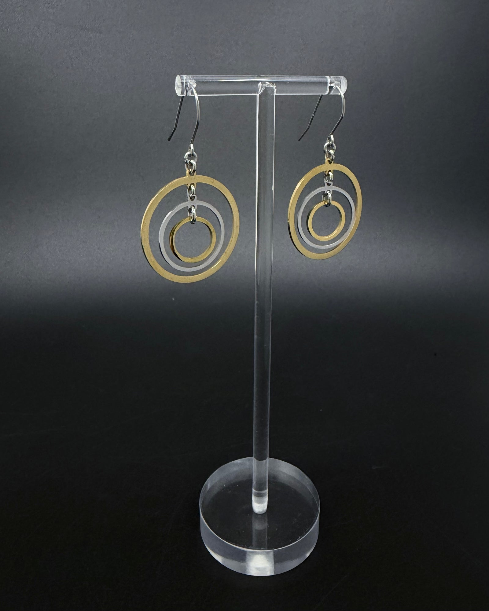 Mixed-metal stainless steel earrings with three interlinked concentric gold and silver rings and stainless steel ear hooks, 5 cm length — Lawless Jewellery.