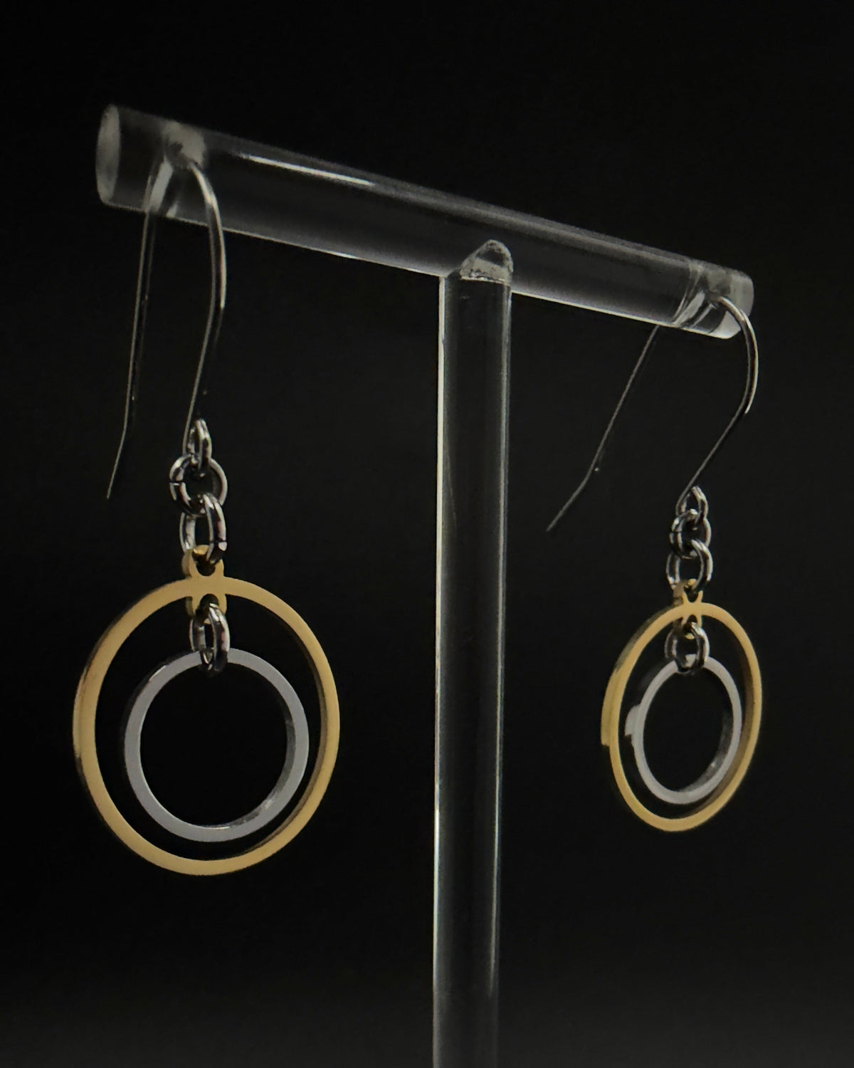 Pair of Cassini Align drop earrings with gold outer rings, silver inner rings and silver hooks displayed in a grey Lawless jewellery box.