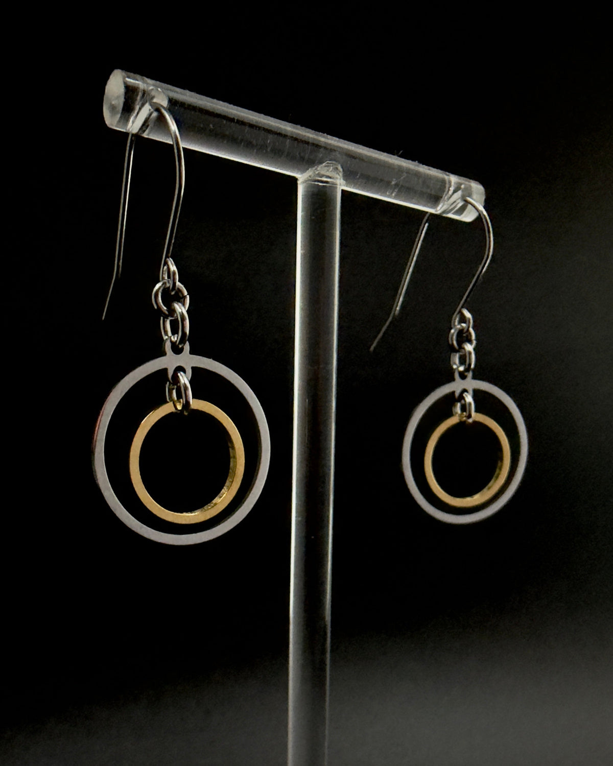 Pair of Cassini Align drop earrings with silver outer rings, gold inner rings and silver stainless steel hooks.
