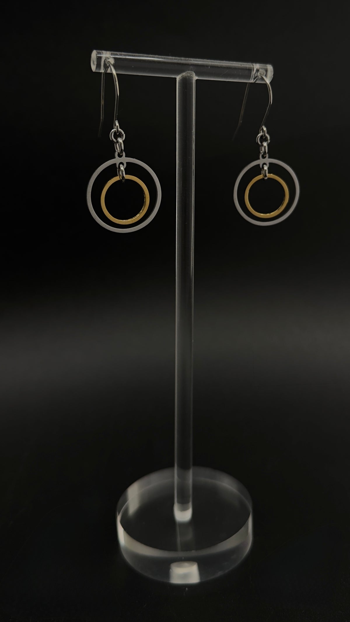 Pair of Cassini Align drop earrings with silver outer rings, gold inner rings and silver stainless steel hooks.