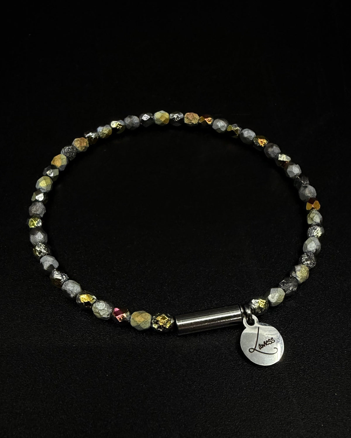Eos Flare Bracelet made from dark faceted fire-polished crystal beads with mixed metallic flashes, a silver screw clasp and Lawless logo tag.