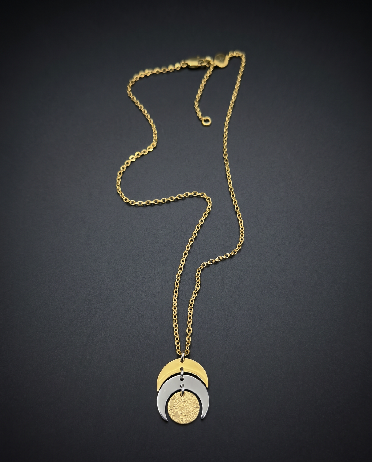 Mixed metal Luna Phase Necklace with silver and gold crescent moon design and textured gold disc on adjustable gold-tone chain