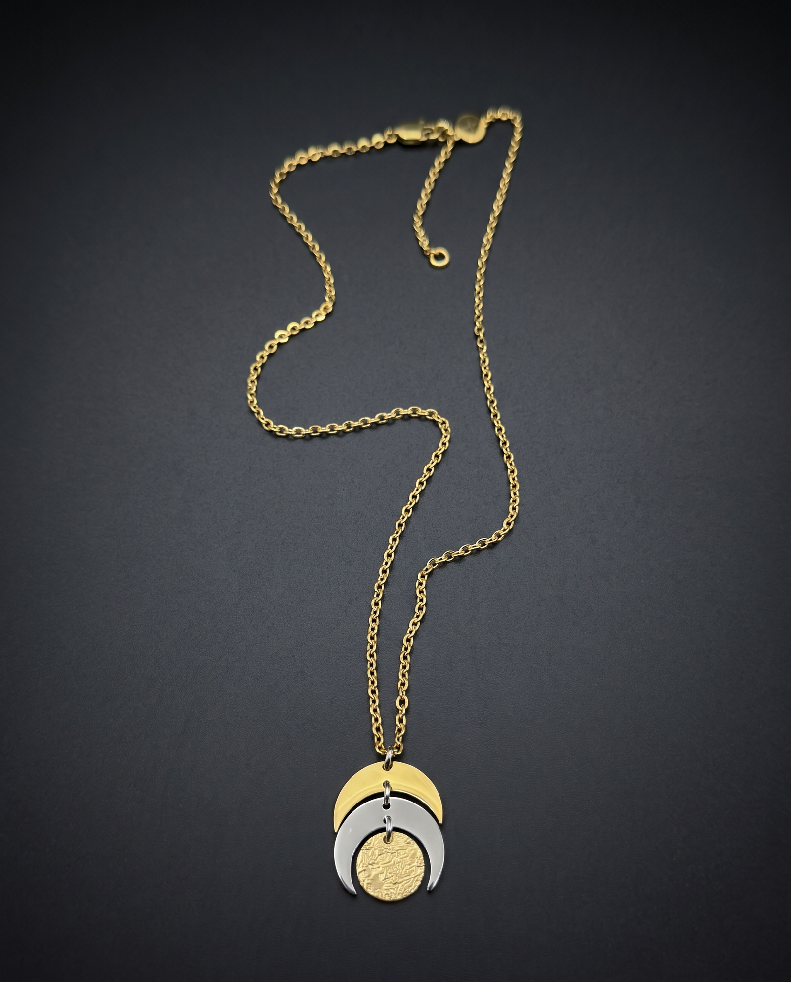 Mixed metal Luna Phase Necklace with silver and gold crescent moon design and textured gold disc on adjustable gold-tone chain