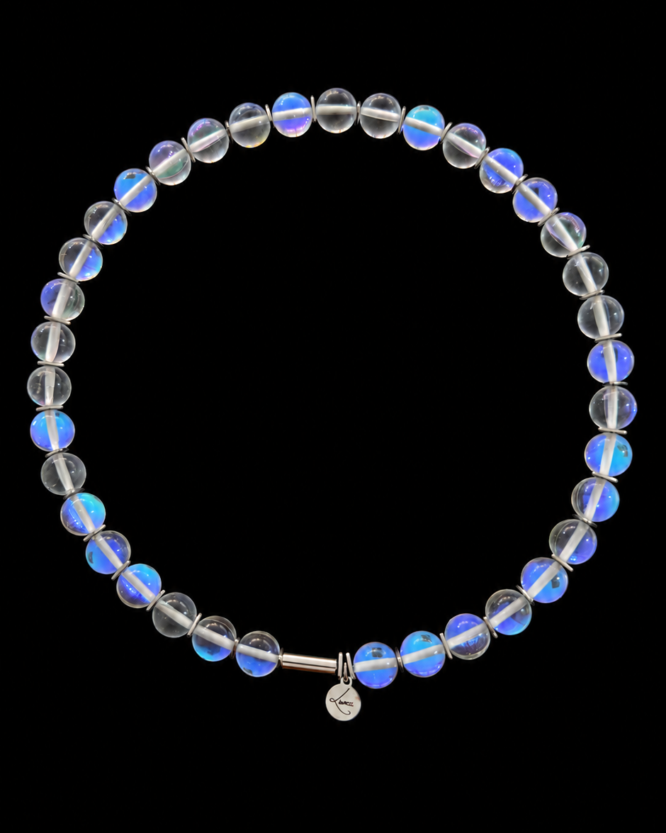 Nebulae Field Necklace featuring a strand of 10mm transparent iridescent glass beads with blue, violet and gold reflections, silver spacers, a stainless steel screw clasp and Lawless logo tag against a black background.