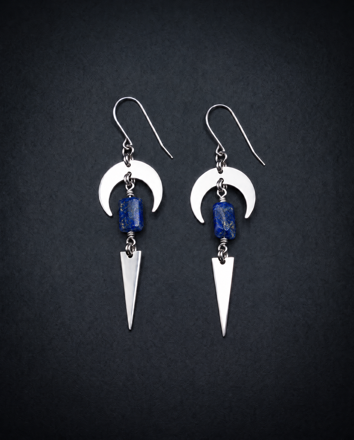 Pair of silver Orion Arc drop earrings with crescent shapes, rectangular deep blue lapis lazuli stones with gold flecks and long triangle pendants.