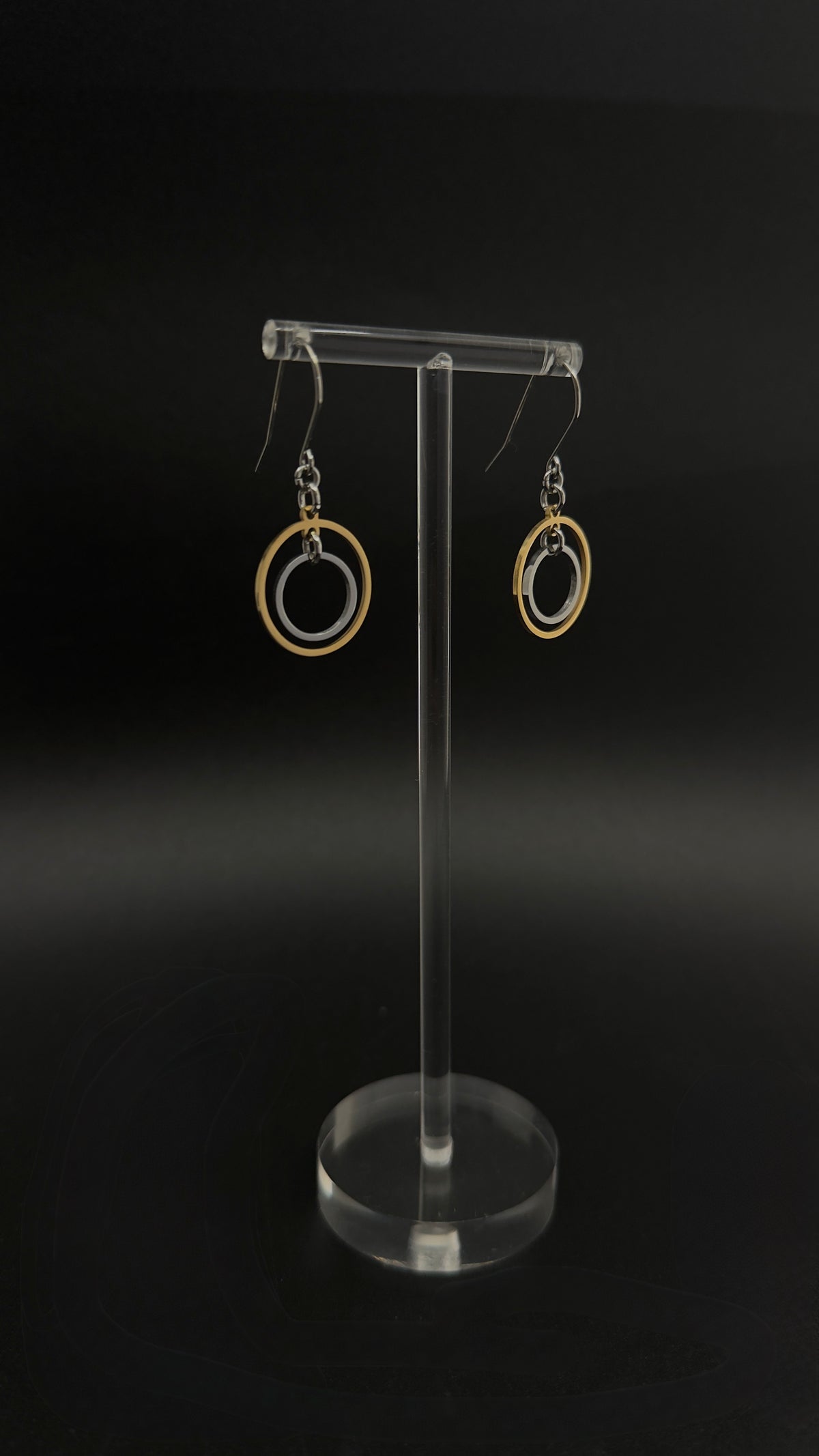 Pair of Cassini Align drop earrings with gold outer rings, silver inner rings and silver hooks displayed in a grey Lawless jewellery box.