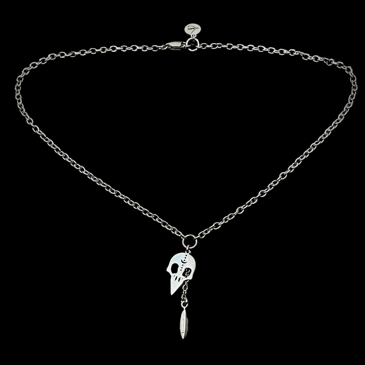Silver necklace with pendant on a gray textured background