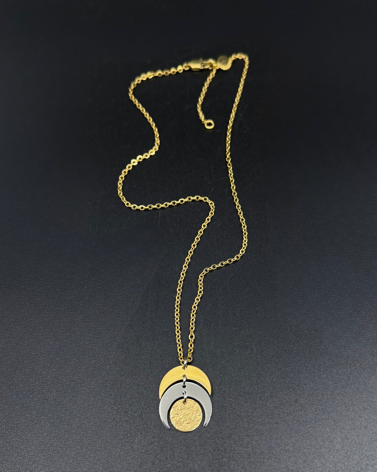 Mixed metal Luna Phase Necklace with silver and gold crescent moon design and textured gold disc on adjustable gold-tone chain