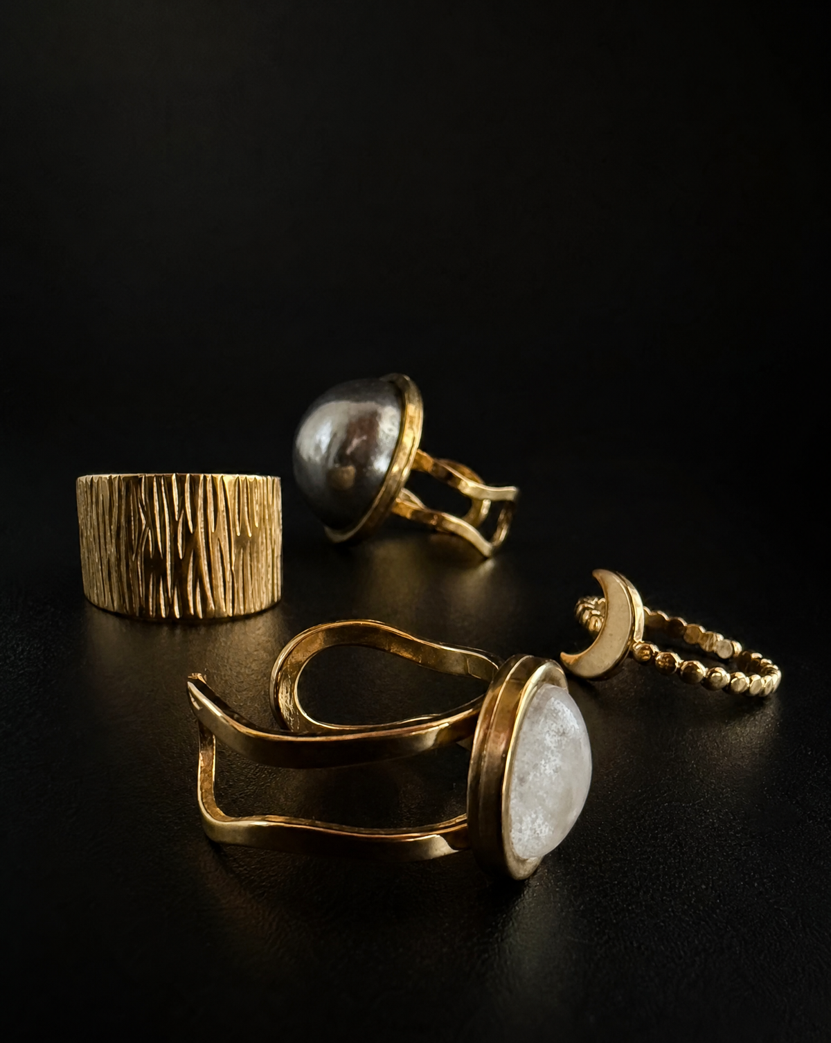 Four gold Nebulae × Cassini rings arranged against a black background, featuring a 20mm steel dome, graduated band, crescent moon and natural quartz crystal.