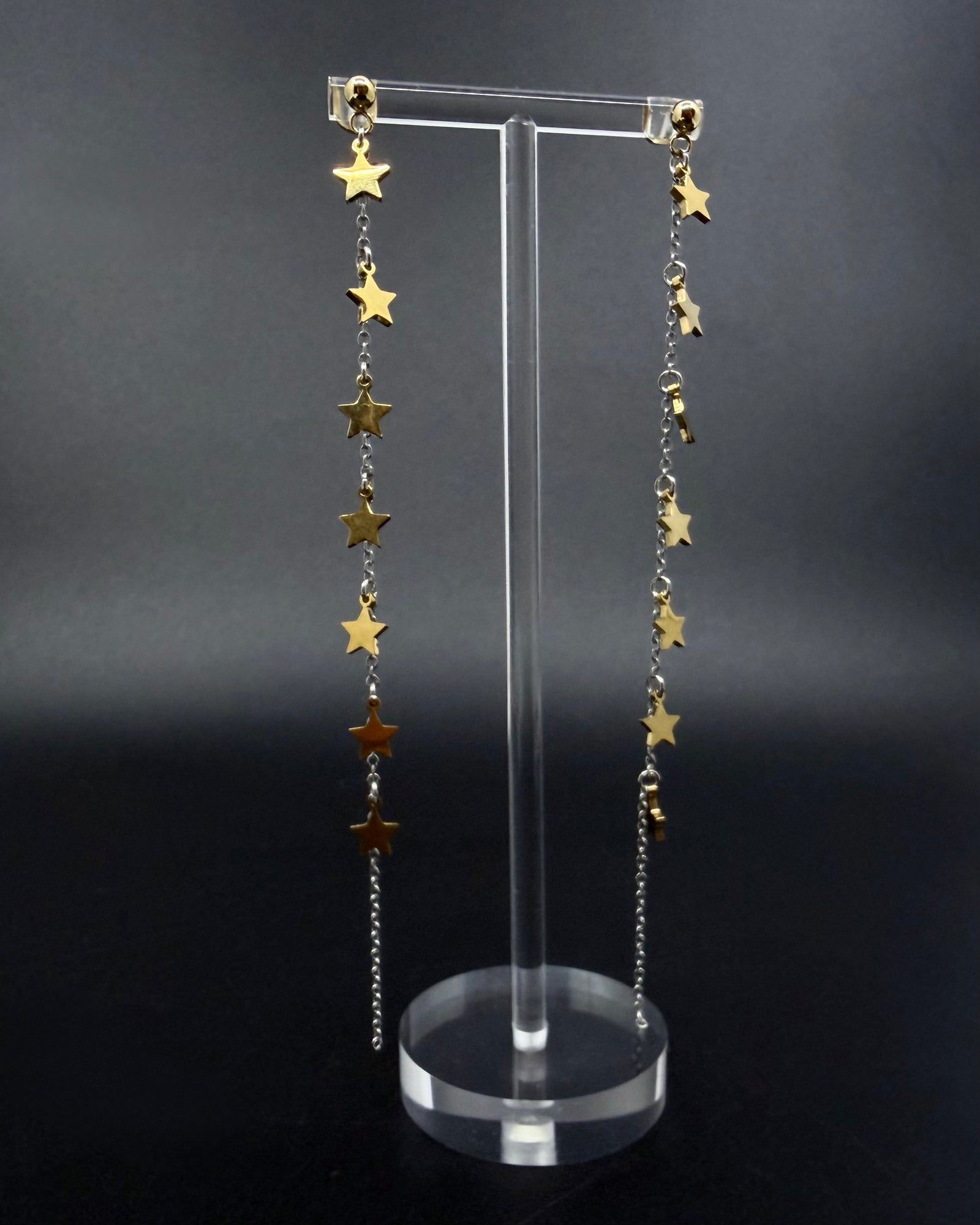 Long mixed-metal celestial drop earrings with gold star charms on silver stainless steel chains, Urania Meridian Earrings by Lawless Jewellery.