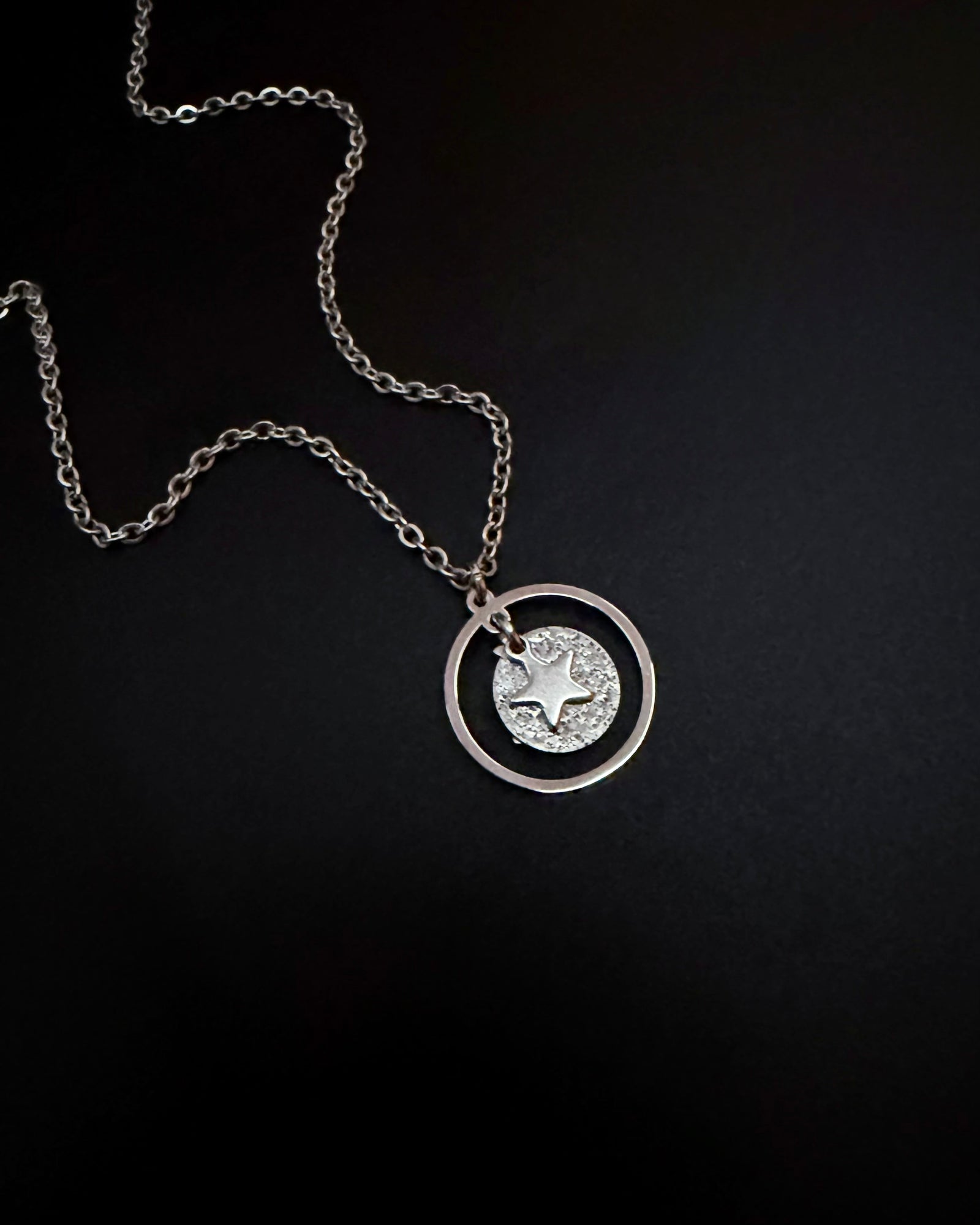 Silver reversible moon and star necklace with textured disc pendant and adjustable chain, Urania Collection by Lawless Jewellery.